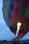 Inflation process and preparation of hot air balloon at sunrise to fly in cloudy sky