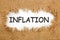 Inflation Written In Hole On The Burlap