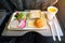 Inflight meal service tray for economy class, meat, fruit, salad, cucumber, a glass of juice and butter. fork knife made of