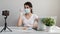 Influencer Girl blogger in medical mask talks about coronavirus. Woman recording video blog tells how to protect