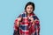 Influenza Concept. Chinese woman in plaid blanket standing  on grey holding cough syrup smiling positive