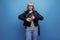 informal energetic healthy gray-haired woman 50s years old grandmother in a rocker jacket on a bright background with