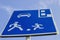 Information road sign, blue rectangular shield with human figures, car and parking marking on blue sky background. Attention,