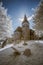 Infrared landscape of old church in churchyard in English countr