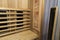 Infrared sauna interior close up view. Wooden walls and bench, ceramic heaters. Healthy lifestyle concept