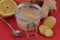 Infusion of fresh ginger and lemon in a glass jar close-up on red background