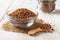 Ingredient for cooking buckwheat porridge concept. Raw organic buckwheat in a glass bowl and wooden spoon on a white wooden