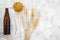 Ingredients for beer. Malting barley near beer glasses and bottle on grey background top view copyspace