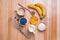 Ingredients for blueberry muffins preparation on wooden table, top view.