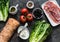 Ingredients for bruschetta - prosciutto, ciabatta bread, romano salad, olives, tomatoes, cream cheese on a dark background, top