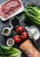 Ingredients for bruschetta - prosciutto, ciabatta bread, romano salad, olives, tomatoes, cream cheese on a dark background, top