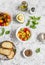 Ingredients for bruschetta - tomatoes, avocado, basil, olive oil, bread. On a light background