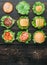 Ingredients for burger. Nine burgers in different stages of readiness. view from above. Black wood background