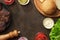 Ingredients for burgers on rusty table.