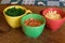 Ingredients in colorful cups on wood table