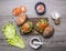 Ingredients for cooking a burger with chicken and vegetables, peppers, tomatoes, lettuce and salt on wooden rustic background top