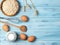 Ingredients for cooking, milk, eggs, oats and kitchenware on blue wooden background, top view