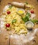 Ingredients for cooking pasta with tomato sauce, eggs ,rolling pin,flour ,olive oil, tomatoes, herbs on on rustic wooden backgroun