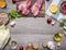 Ingredients for cooking pork steak with vegetables, fruits, spices, laid out by frame,place text on wooden rustic background