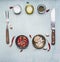 Ingredients for cooking, seasoning, oil, knife, fork, garlic, hot red pepper, lined frame on wooden rustic background top view clo