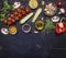 Ingredients for cooking vegetarian food tomatoes on a branch, herbs, cucumber, lemon, garlic, oil, black pepper, paprika, mushroom