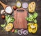 Ingredients for cooking vegetarian pasta with flour, vegetables, oil and herbs, onion, pepper laid out around cutting board on w