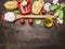 Ingredients for cooking vegetarian pasta with vegetables, a wooden spoon, herbs and butter on wooden rustic background top view cl