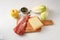 Ingredients for an endive or chicory gratin with apple, ham, cheese and pumpkin seeds on a kitchen board and a white table with