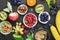Ingredients for healthy breakfast meals: raspberries, blueberries, nuts, orange, bananas, grapes blue, green, apples