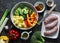 Ingredients for healthy comfort  lunch - turkey sausages, potatoes, broccoli, sweet peppers, spices on a dark background, top view