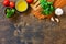 Ingredients for italy cuisine. Tomato spaghetti, herbs spices, olive oil and vegetables on a wooden table.