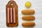 Ingredients for making hotdogs: sausages on wooden board, hot-dog buns and mustard on white wooden table, overhead view.