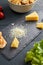 Ingredients for making salad. Piece and grated parmesan cheese on black serving board