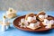 Ingredients for making smores on a clay plate: marshmallows, milk chocolate, wheat cracker. American food