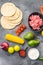 Ingredients for meat mexican tacos , corn tortillas, chili pepper, avocado, meat  on textured grey background, top view