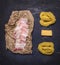 Ingredients for pasta carbonara, bacon on paper, paste, parmesan cheese on wooden rustic background top view close up