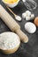 Ingredients for pastries: flour, eggs, milk against a dark backg