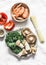 Ingredients for preparing  asian style lunch - shrimp, egg noodles, sweet pepper, kale, shiitake mushrooms on a light background,