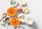 Ingredients for pumpkin apple soup on white background, top view. Pumpkin, apples, cream, onion, sage