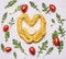 Ingredients raw pasta heart lined with cherry tomatoes arugula garlic wooden rustic background close up top view