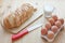 Ingredients for toast. Sliced white bread, eggs, milk glass and knife on wooden background