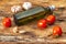 Ingredients of traditional Italian cuisine. Olive oil, tomatoes, garlic. Cooking wooden bark background