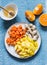 Ingredients for vitamin smoothies - fresh ripe mango, carrot, orange, honey, ginger on a blue background, top view. Detox healthy