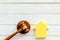 Inheritance of the house concept with figure and gavel on white wooden background top view space for text