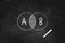 Initial letters A and B balance overlapping  in Venn diagram drawn with chalk on black board icon logo design illustration symbol