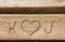 Initials of a love couple, carved in a bench plank