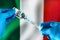 Injecting dose of vaccine in syringe for Covid-19 over the Italian flag