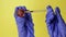 Injection into an grape. Hand in medical glove with syringe on yellow background. Genetic modified foods. Injection of GMOs
