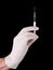 Injection - hand with syringe needle over black
