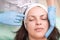 Injection into the skin of the face of a young woman, close up. Doctor cosmetologist using a syringe with a needle, injects a